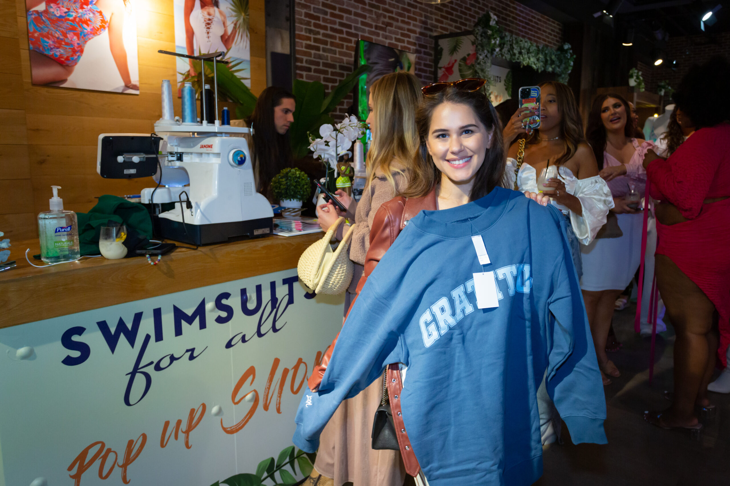 Girl Holding Blue Sweatshirt at Pop-Up Shop