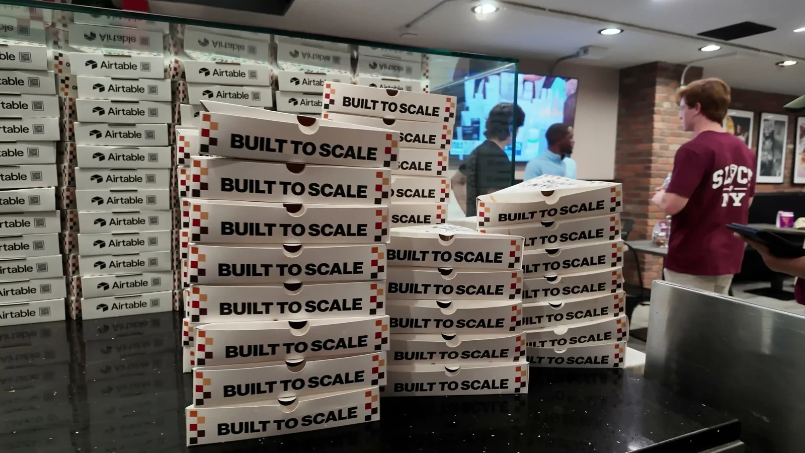 Custom Airtable pizza packaging inside the activation · frame from the campaign film.
