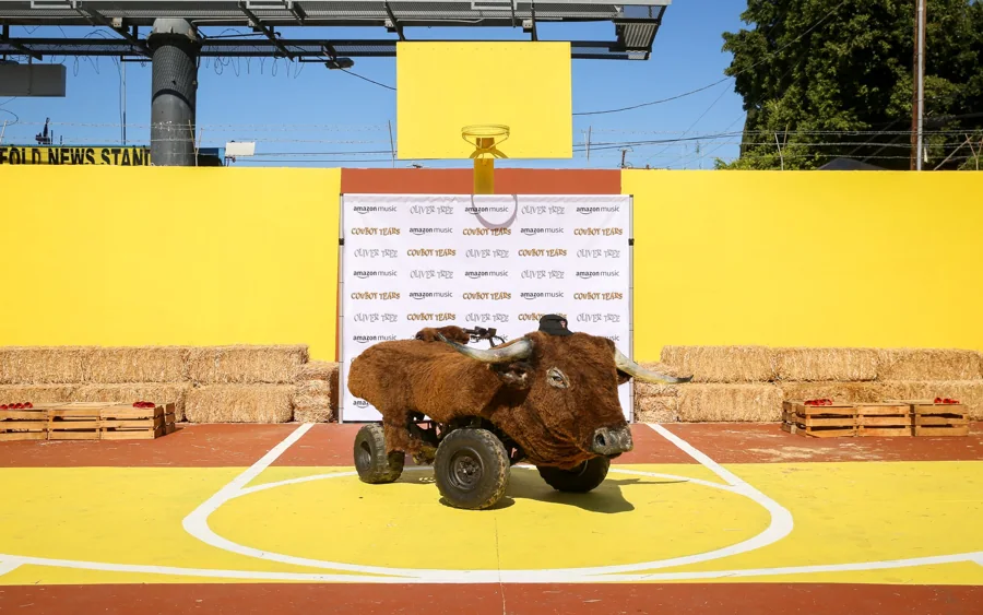 A bull-shaped vehicle on a yellow basketball court at Oliver Tree’s Cowboy Tears activation.