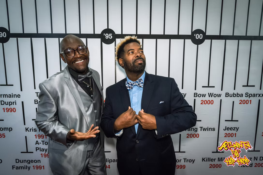 Guests talk in front of the exhibition’s Atlanta music timeline.