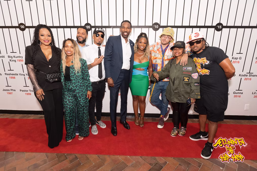 A group portrait on the red carpet in front of the Atlanta music timeline.