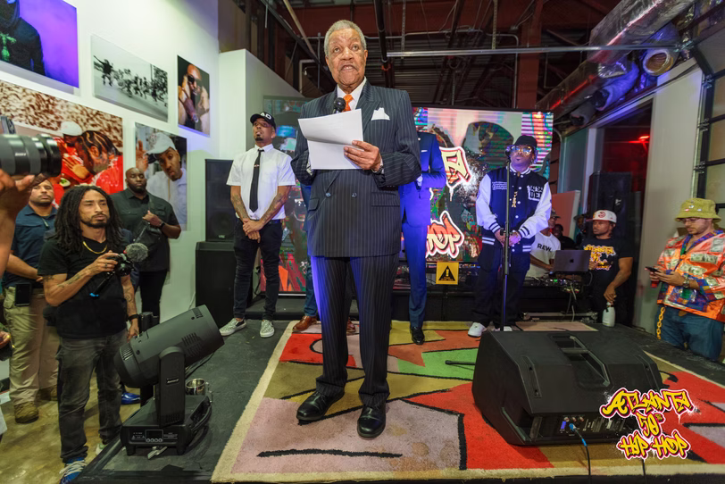 A speaker holds notes on the stage during the opening event.
