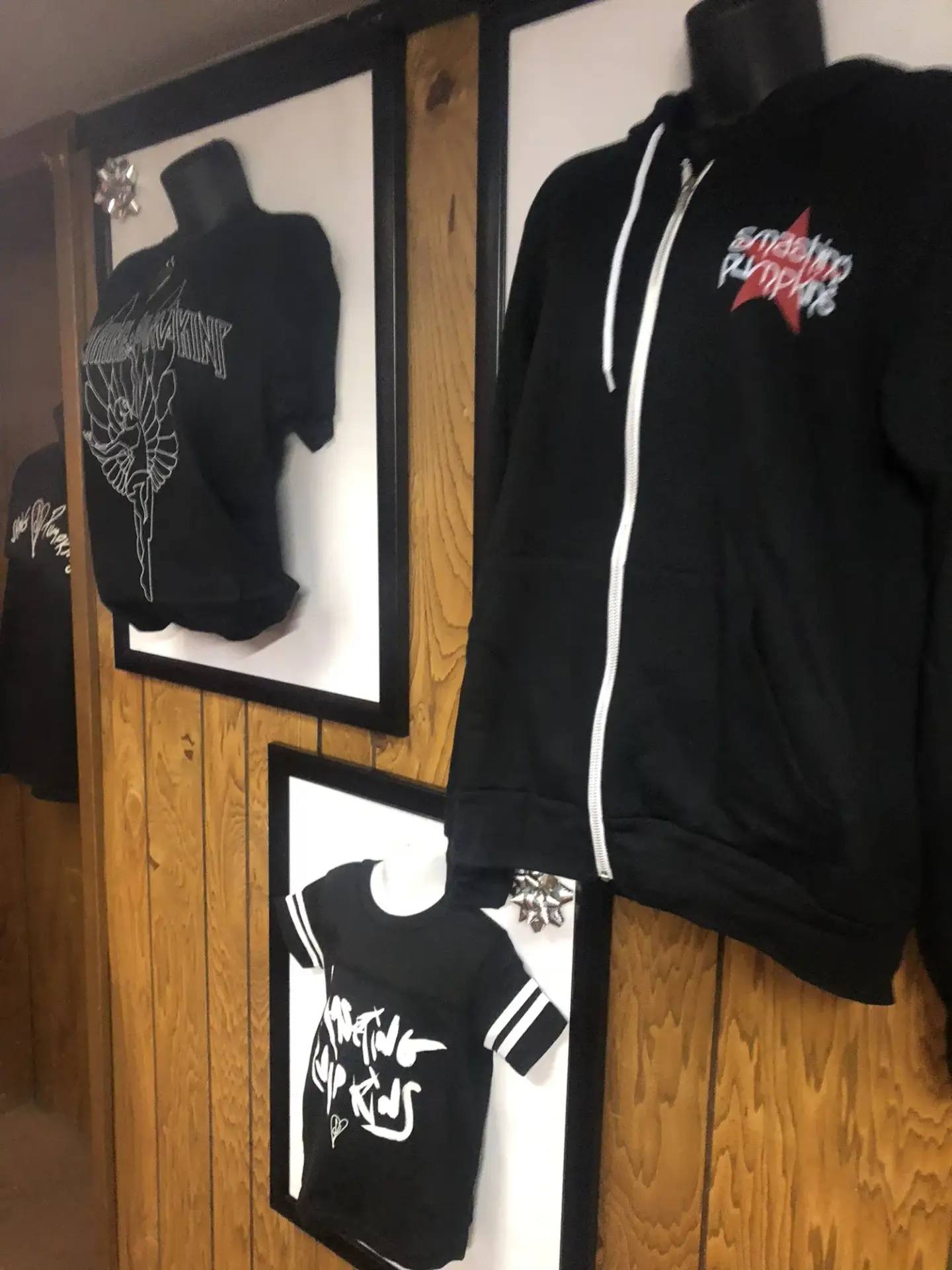 T-shirts and a hoodie presented in individual wall frames.