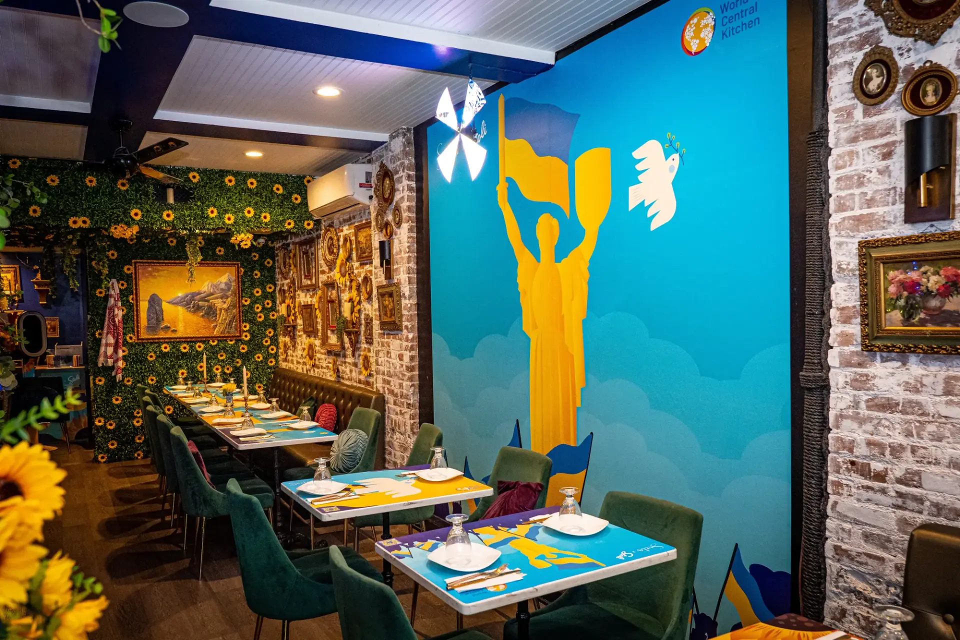 The completed wall graphic, with World Central Kitchen identification, beside the restaurant’s dining tables.
