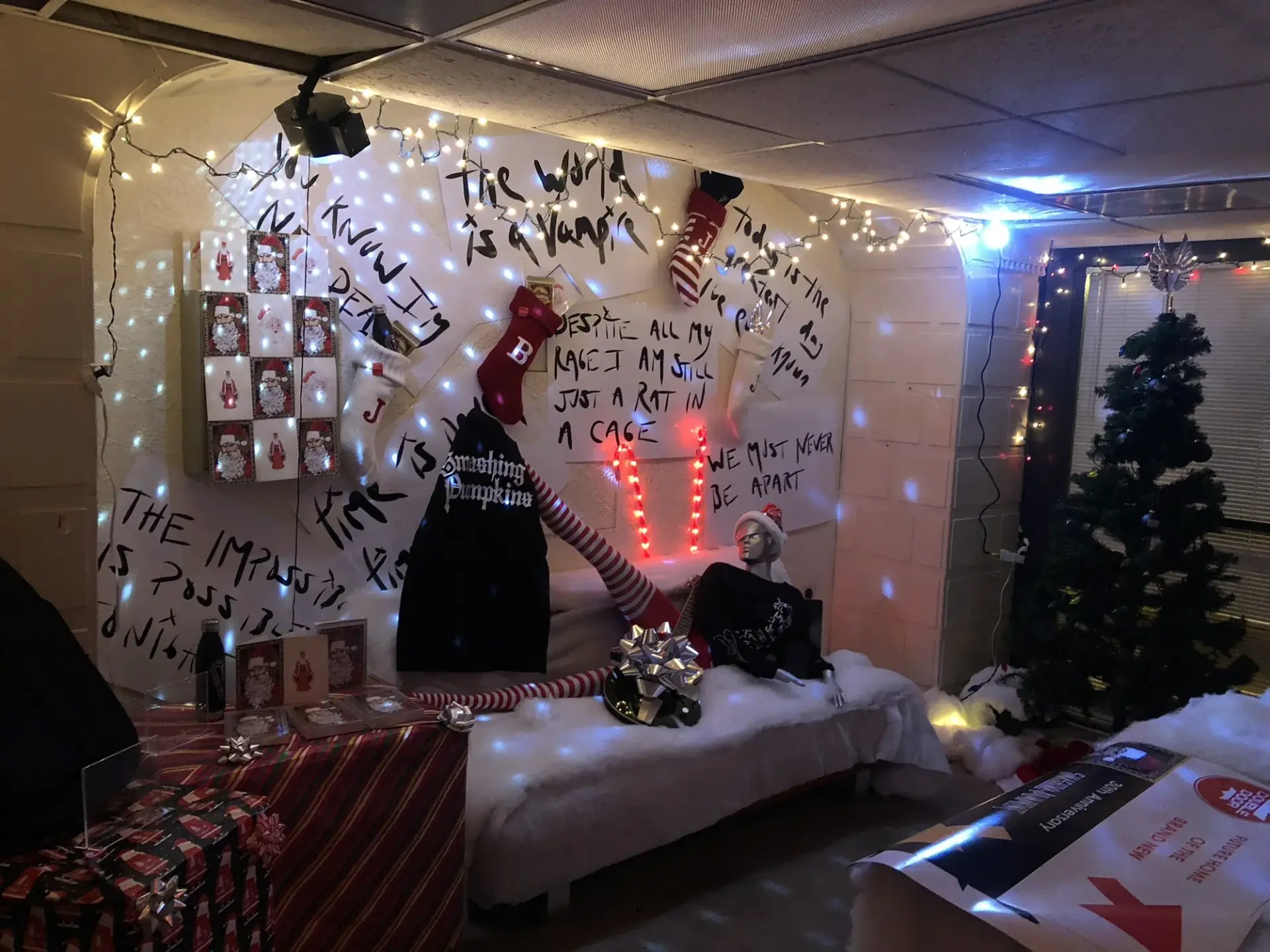 A furnished fan lounge with handwritten graphics and decorative lighting beside the retail displays.