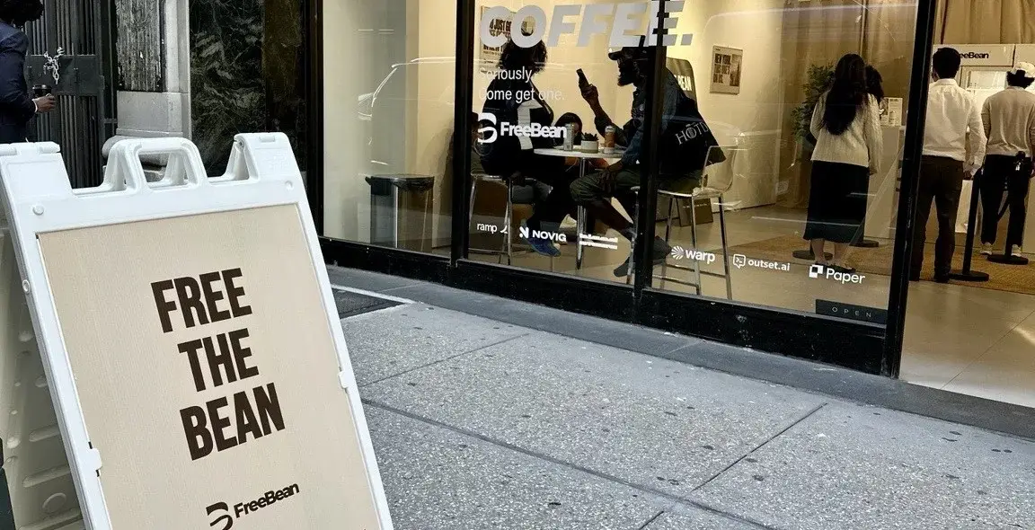 The A-frame and window graphics invite passersby into FreeBean · opening-day photography.