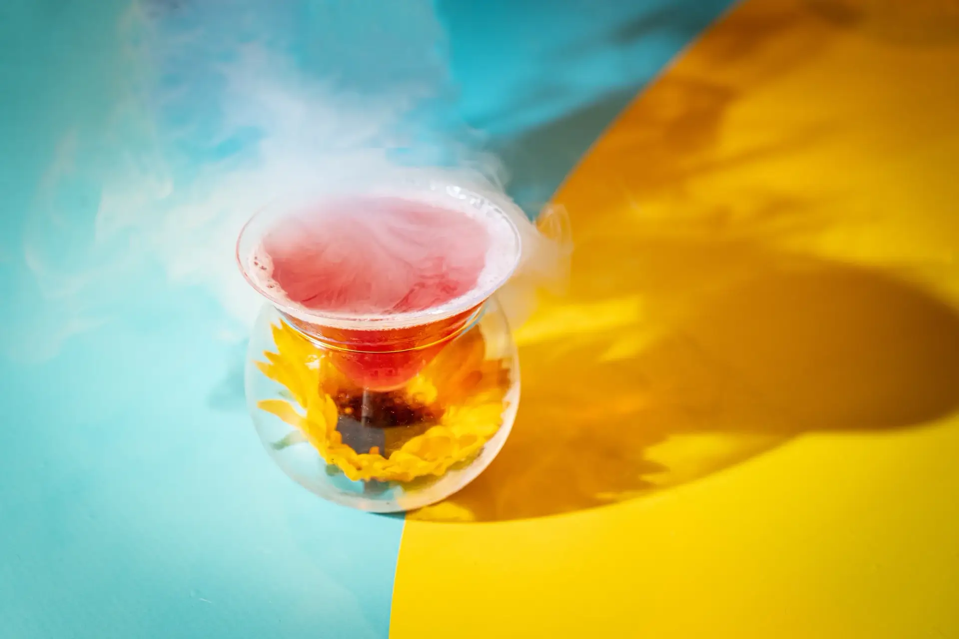 A theatrical cocktail served against the campaign’s blue-and-yellow table graphics.