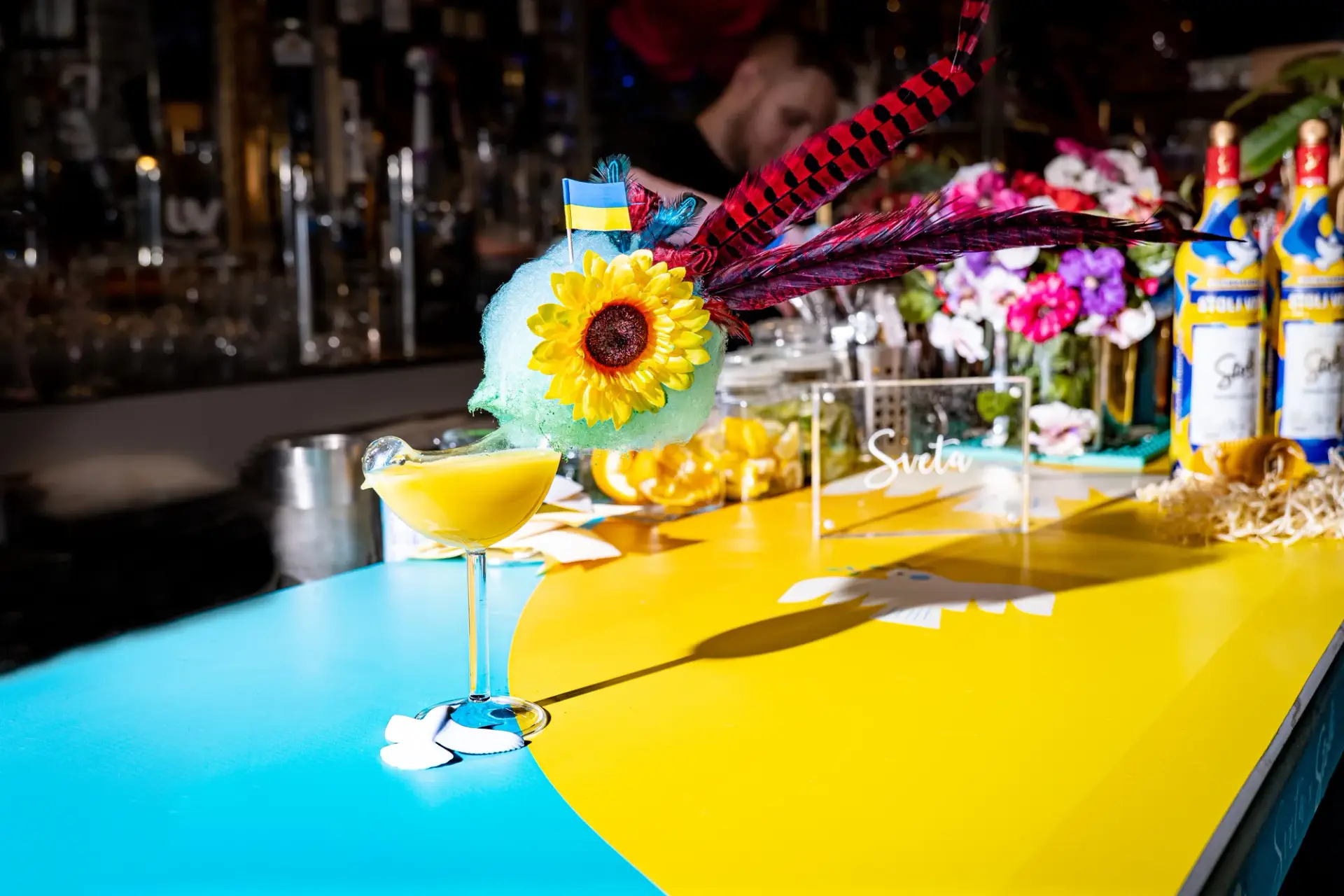 Blue-and-yellow bar surfaces with the campaign bottle presentation.